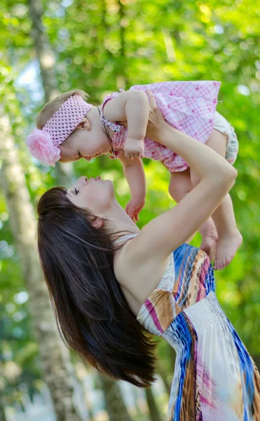 Mom picks up baby girl — Stock Photo, Image