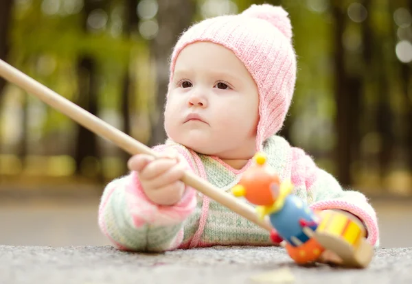 Criança com um brinquedo de madeira — Fotografia de Stock