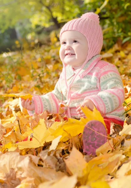 Baby in de gele bladeren — Stockfoto