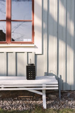 Otantik İskandinav yerleşim yerinin dış tarafı pencere, bank ve fenerli ahşap evin bir parçası.