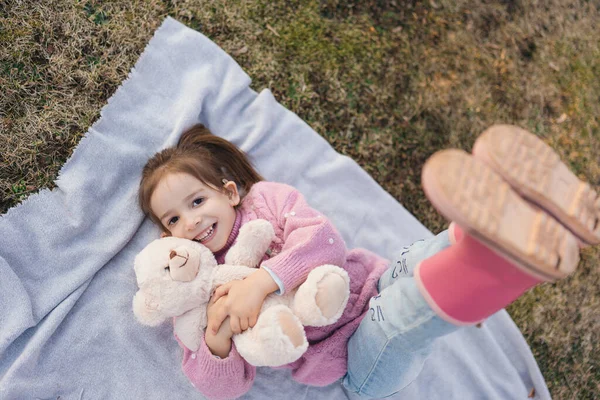 Mutlu Küçük Kız Örgü Süveter Lastik Botlarla Çimenlerin Üzerinde Oyuncak — Stok fotoğraf