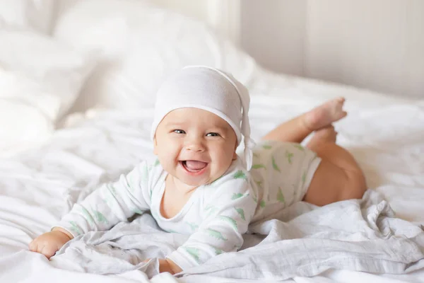 Happy Baby White Bodysuit Cap Crawls White Bed Smile — стоковое фото