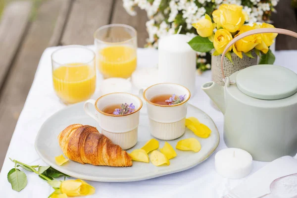 Teeparty Garten Kräutertee Teekanne Orangensaft Croissant Gelbe Rosen Und Weiße — Stockfoto