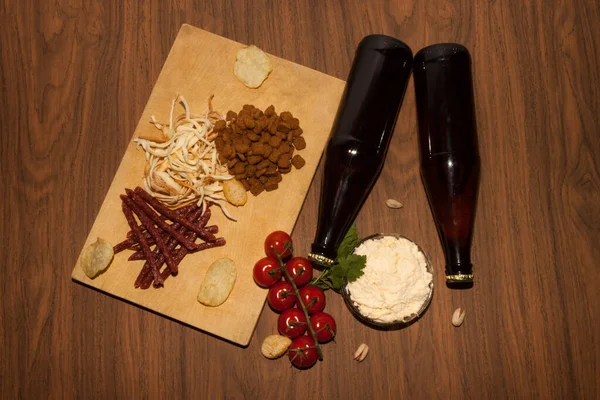 Cips, abur cubur, fındık karışımı, bira ve bira. Koyu arkaplan. 