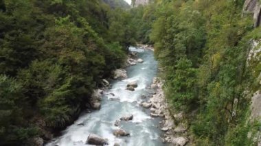 Dağlardaki bir nehirdeki insansız hava aracının hava görüntüsü. Dağlık bir bölgede terk edilmiş eski bir yol..