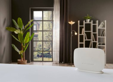 Masadaki beyaz modemi kapat ve dekoratif oturma odası arka plan stili.