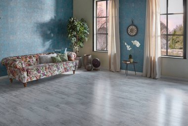 Mavi duvar kağıdı odasındaki çiçek desenli kanepe, yeşil bitki vazosu, saat ve perde, parke zemin modern oda..