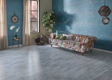 Mavi duvar kağıdı odasındaki çiçek desenli kanepe, yeşil bitki vazosu, saat ve perde, parke zemin modern oda..