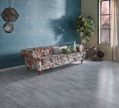 Mavi duvar kağıdı odasındaki çiçek desenli kanepe, yeşil bitki vazosu, saat ve perde, parke zemin modern oda..