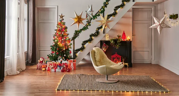 Modern sofa Christmas New Year concept with pine tree gift box and fireplace, decorative led lamp, stairs and door background, grey wall, wicker carpet design.