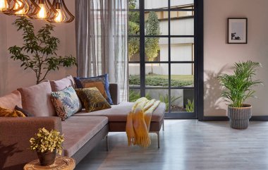 Oda içi kanepe ve çalışma masası tarzı, metal lamba, vazo, bitki, bahçe manzarası, orta kahve masası, battaniye, parke zemin, ev tasarımı..