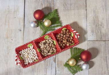 Nuts in the Christmas plate, Noel ornaments and wooden background.