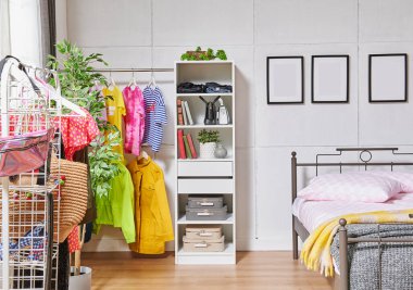 Metal bedstead in the bed room, white wall background, frame, wardrobe, clothes and blanket style.