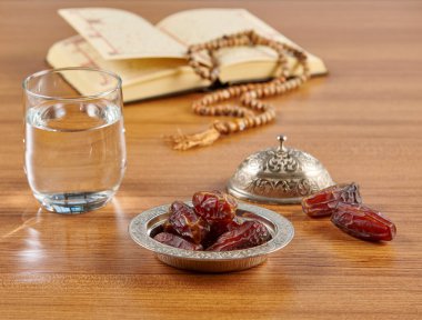 Ramazan mevsimi su ve Türk tarzı çinko gümüş tabak, ahşap masada tespih tarzı..