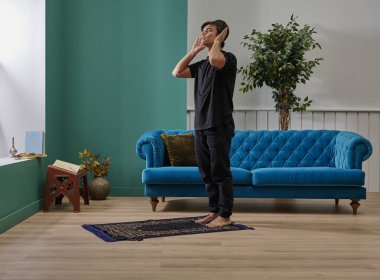 Oturma odasında dua eden adam ev konsepti.