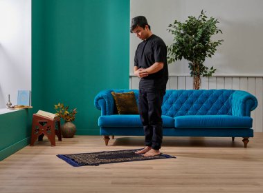 Oturma odasında dua eden adam ev konsepti.