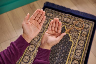 Müslüman adam dua ediyor, ibadet halısının üzerinde oturuyor, iç mekan, ramazan, tespih, açık el, İslam, Ramazan, Cuma.
