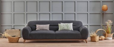 Dekoratif oturma odası konsepti gri duvar arka plan stili, mobilya tasarımı, kanepe, yastık ve pamuk çiçekli battaniye.