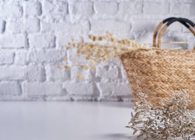 Pamuk çiçek ve hasır çanta vazo beyaz masa üzerinde bitki tarzı, tuğla duvar arka planı, natürmort yaşam, dekorasyon.