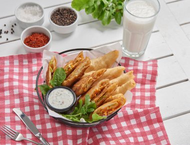 Fried spring roll basket plate with sauce, food style.