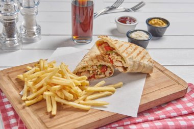Wrap and fried tomato on the cutting board presentation style.