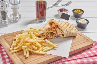 Wrap and fried tomato on the cutting board presentation style.