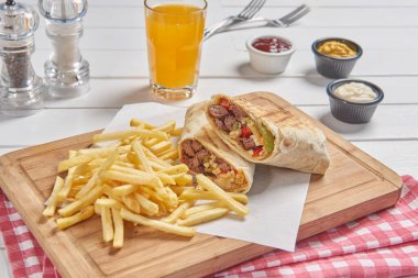 Wrap and fried tomato on the cutting board presentation style.