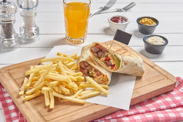 Wrap and fried tomato on the cutting board presentation style.