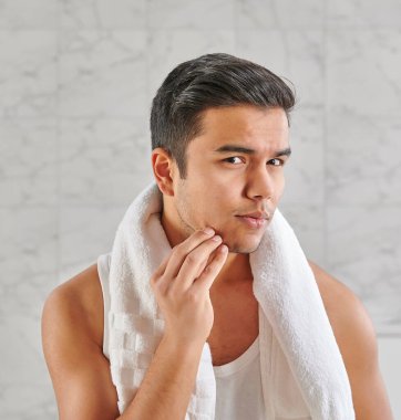 Man who wants to shave in front of the mirror, athlete and towel style, beard in the bathroom. Uzbekistan people.