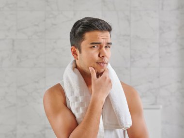 Man who wants to shave in front of the mirror, athlete and towel style, beard in the bathroom. Uzbekistan people.