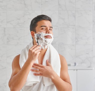 Man who wants to shave in front of the mirror, athlete and towel style, beard in the bathroom. Uzbekistan people.