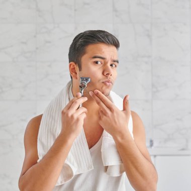 Man who wants to shave in front of the mirror, athlete and towel style, beard in the bathroom. Uzbekistan people.