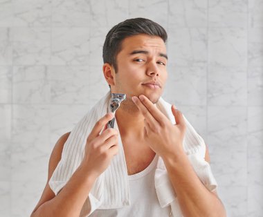 Man who wants to shave in front of the mirror, athlete and towel style, beard in the bathroom. Uzbekistan people.