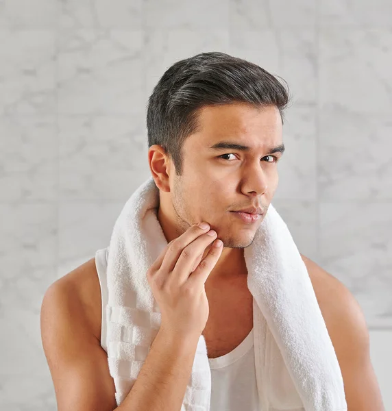 Man who wants to shave in front of the mirror, athlete and towel style, beard in the bathroom. Uzbekistan people.