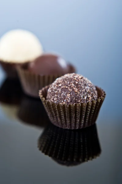 Σοκολατάκια πολυτέλεια σοκολάτας σε μια γραμμή με την αντανάκλαση. — Φωτογραφία Αρχείου