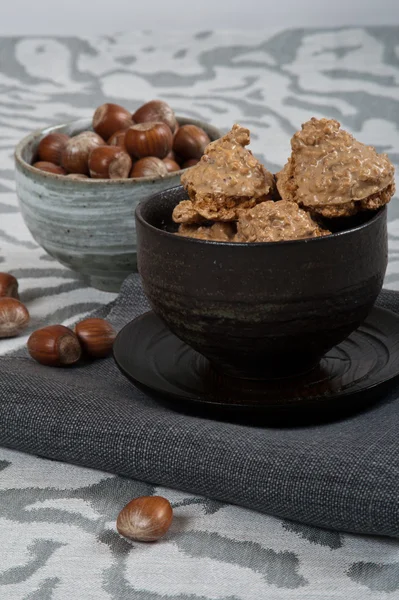 Italian cookies called "brutti ma buoni" with hazelnuts and a modern tablecloth — Stock Photo, Image