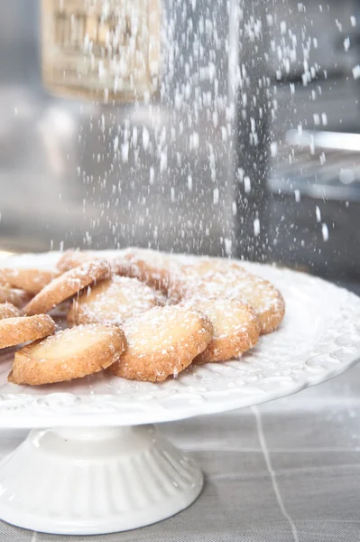 Cookies op een witte riser onder een wit poeder suiker — Stockfoto