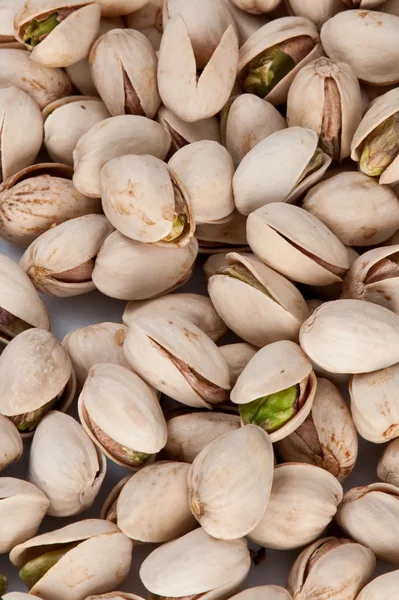 Bakgrund av pistagenötter på ett vitt bord — Stockfoto