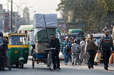 insanlar, otomobil, motosiklet ve bisiklet Yeni Delhi, Hindistan sokakta trafik. Hindistan'da seyahat sırasında bir sabah. bir sürü insan her yerde sokakta yürürken taşıma.