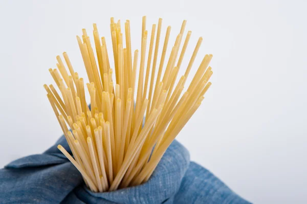 Bando de espaguete em um blu guardanapos leves prontos para cozinhar uma receita italiana . — Fotografia de Stock