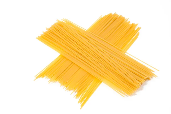 Bando de espaguete no fundo branco pronto para ser cozido em uma receita italiana — Fotografia de Stock