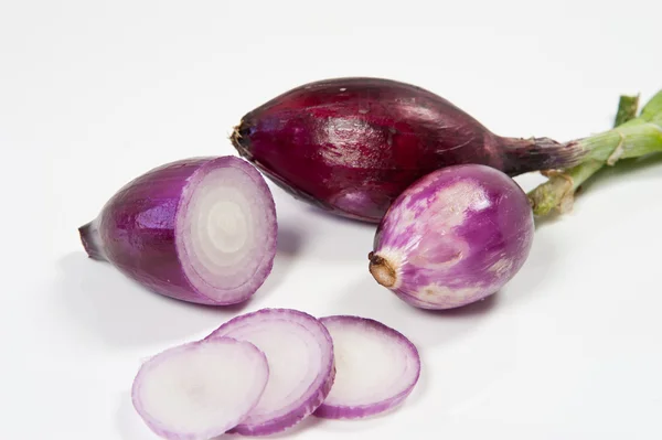 Cebola Tropea vermelha e cortada em um fundo branco — Fotografia de Stock