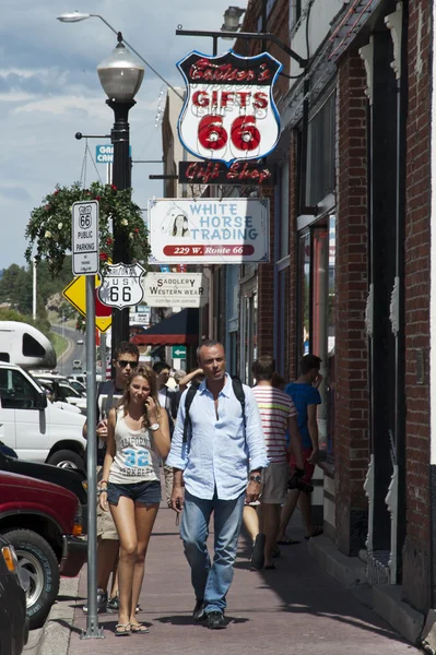 Many people during their holiday like to follow the route 66 from California to Arizona. We can see same tourist walking and visiting shops in the streets of the small city of williams on the 66 route — Stock Photo, Image