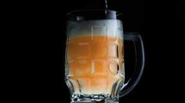Su damlalarıyla dolu bir bardakta soğuk bira. Şişeden bira dökülüyor.. 