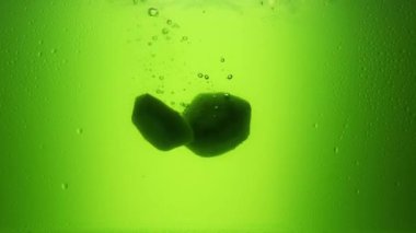  Kivi meyve suyuna düşer. Yavaş çekim 240 fps. Yeşil meyve suyu. Taze meyve.
