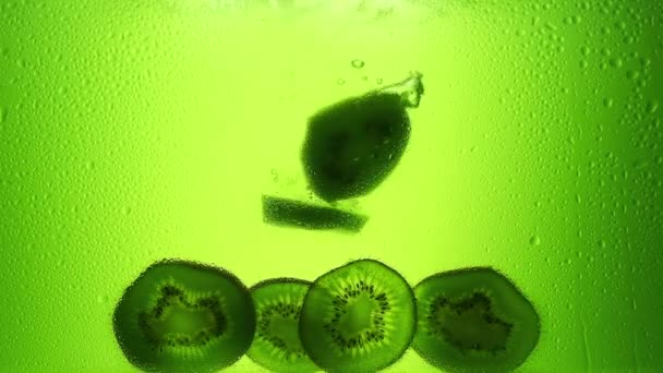 キウイはジュースに落ちます スローモーション240Fps 緑のジュース 新鮮な果物 — ストック動画