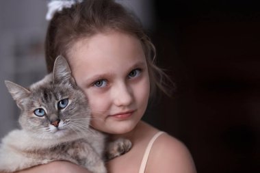 Siyam kedisi olan bir çocuk portresi.