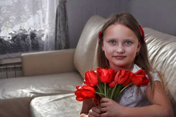 Barn leende porträtt med blommor på soffan hemma vardagsrum — Stockfoto