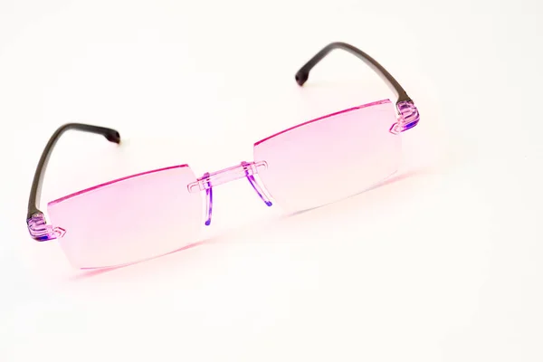Óculos cor-de-rosa para visão sobre um fundo branco — Fotografia de Stock