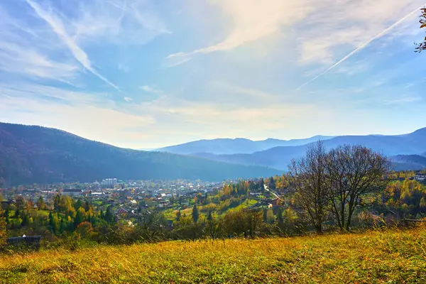 Bergkette und Dorf in Herbstfarben und blauem Himmel — Stockfoto